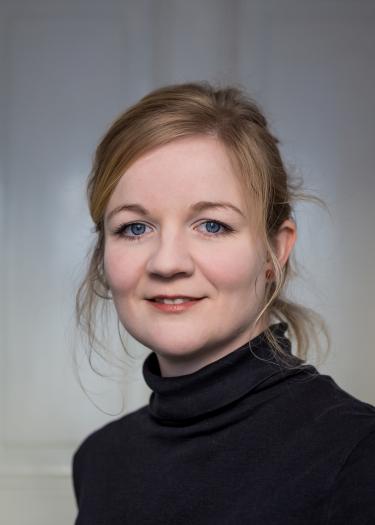 Dunkelblonde frau mit hochgebundenem Haar in schwarzem Rollkragenpullover